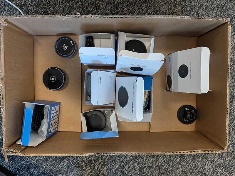 A box containing a wide array of wireless charging attachments