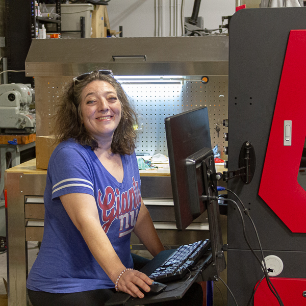 Kira in the warehouse working on laser engraving machine