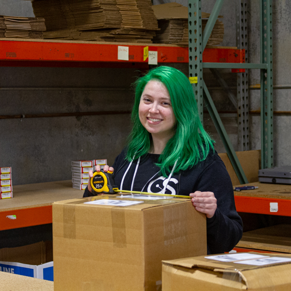 Lauren in the warehouse taping up a package